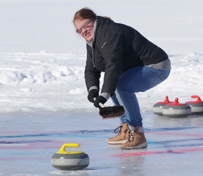 Mara Bonnell, of Fond du Lac, watches the stone glide on Lake Winnebago while curling during the Sturgeon Spectacular, Saturday, February 11, 2023, in Fond du Lac, Wis.