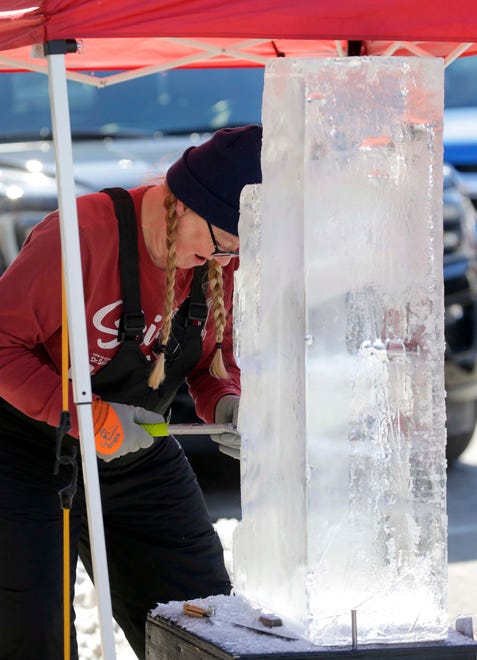 Kate Fons, of Milwaukee, Wis., carves a block of ice in honor of her father during the Sturgeon Spectacular, Saturday, February 11, 2023, in Fond du Lac, Wis. She named her sculpture Bumpa.