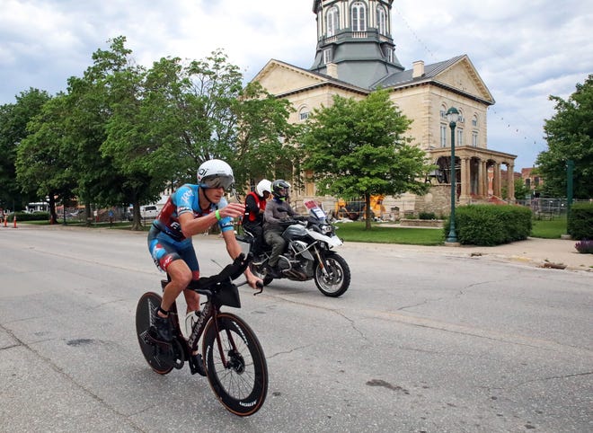 Matthew Hanson of the United States, a Buena Vista University graduate, leads as he races by the Madison County Courthouse on John Wayne Drive in Winterset during the Ironman North American Championship 140.6-mile Des Moines Triathlon as athletes compete in a 2.4-mile swim at Gray’s Lake, 112-mile bike race, and a 26.2-mile run in the Des Moines metro on Sunday, June 12, 2022. This regional competition offered qualifying slots to the 2022 Ironman World Championship in Kailua-Kona, Hawaii, in early October 2022.