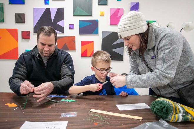 Scott Krebsbach, left, helps is son Isaac, 5, create a Sturgeon mobile, as mom Heather helps during the Sturgeon Spectacular, Saturday, February 11, 2023, in Fond du Lac, Wis.