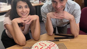 Green Bay reporters Natalie Eilbert and Jeff Bollier posing with the chocolate and coffee cake Eilbert made for Bollier's 20th work anniversary.