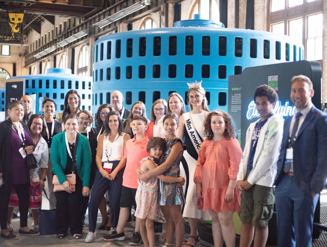 Grace Stanke poses with a tour group at a facility in Canada as Miss America.