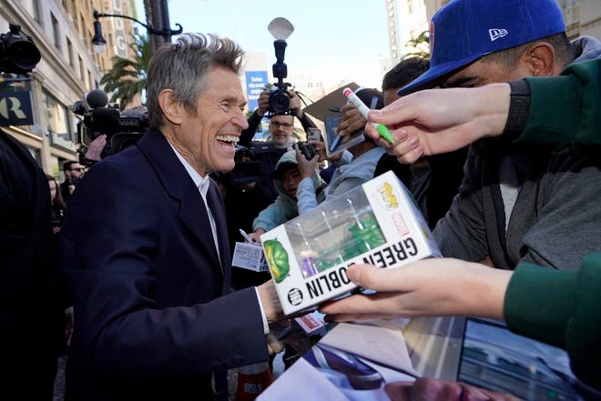 Willem Dafoe gets ready to sign a Green Goblin package for a fan after a ceremony honoring Dafoe with a star on the Hollywood Walk of Fame, Monday, Jan. 8, 2024, in Los Angeles.
