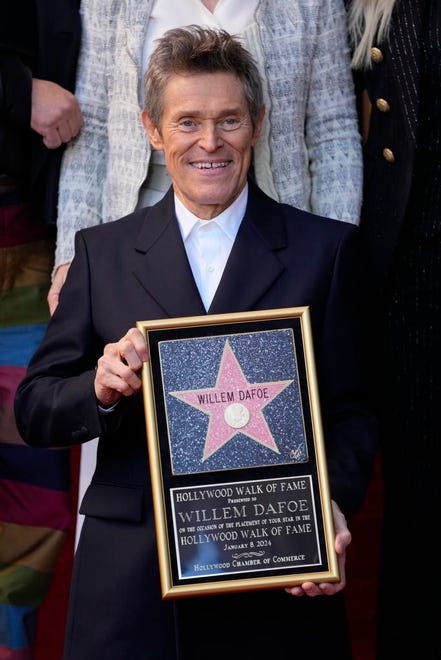 Willem Dafoe holds a plaque at a ceremony honoring him with a star on the Hollywood Walk of Fame, Monday, Jan. 8, 2024, in Los Angeles.