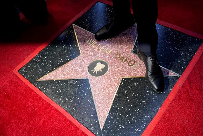 Willem Dafoe stands over his star at a ceremony honoring him with the star on the Hollywood Walk of Fame, Monday, Jan. 8, 2024, in Los Angeles.