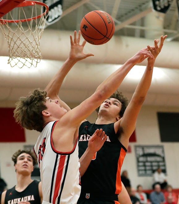 Kaukauna High School's Andrew Jensen (5) pulls down a rebound against Kimberly High School's Landon VanOfferen (23) during their boys basketball game Wednesday, January 10, 2024, in Kimberly, Wisconsin. Kimberly won 73-72 in double overtime.