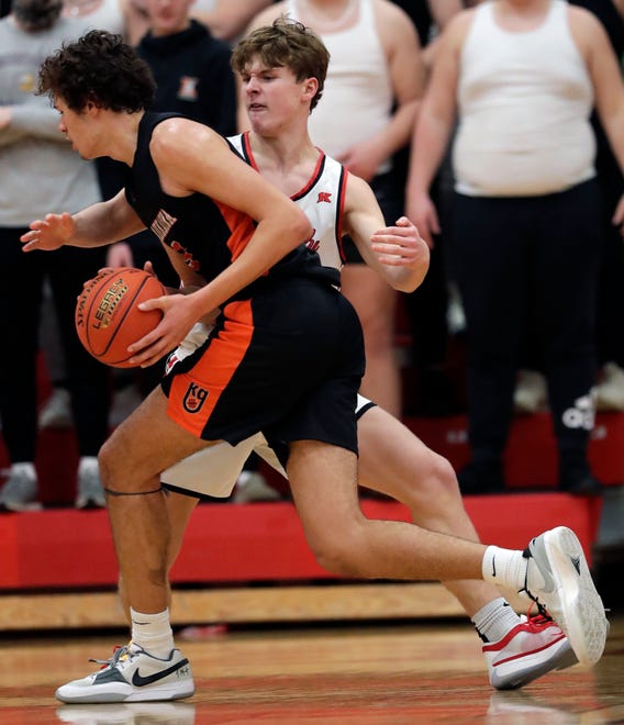 Kimberly High School's Landon VanOfferen (23) fouls Kaukauna High School's Andrew Jensen (5) during their boys basketball game Wednesday, January 10, 2024, in Kimberly, Wisconsin. Kimberly won 73-72 in double overtime.