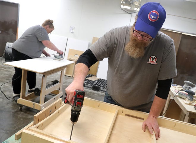 Owners Tony Bishell, right, and Stephanie Bishell work at Skilled Cornhole, a family-owned business, that makes custom, handcrafted cornhole boards on Friday, January 26, 2024 in Appleton, Wis.