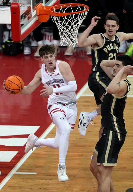 Wisconsin guard Max Klesmit (11) passes around Purdue center Zach Edey (15) during the first half of their game Sunday, February 4, 2024 at the Kohl Center in Madison, Wisconsin.