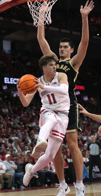 Wisconsin guard Max Klesmit (11) finds an open teammate while being guarded by Purdue center Zach Edey (15) during the second half of their game Sunday, February 4, 2024 at the Kohl Center in Madison, Wisconsin. Purdue beat Wisconsin 75-69.