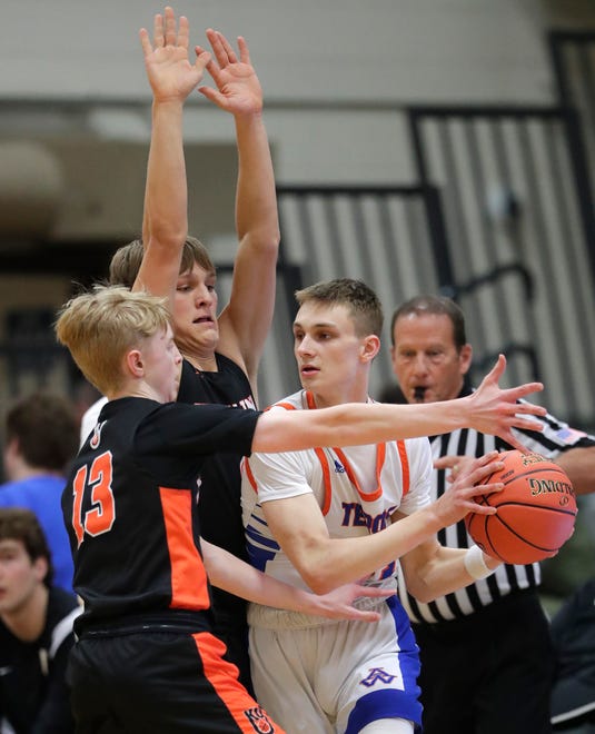 Kaukauna High School's Jonah Roehrig (13) and Nathan Deprez (4) defend against Appleton West High School's Lucas Downs (13) during their boys basketball game Friday, February 2, 2024, in Appleton, Wisconsin. Kaukauna won 95-48.