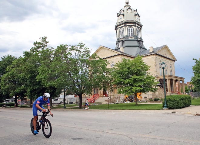 Matt Russell of the United States races by the Madison County Courthouse on John Wayne Drive in Winterset during the Ironman North American Championship 140.6-mile Des Moines Triathlon as athletes compete in a 2.4-mile swim at Gray’s Lake, 112-mile bike race, and a 26.2-mile run in Des Moines on Sunday, June 12, 2022. This regional competition will offer qualifying slots to the 2022 Ironman World Championship in Kailua-Kona, Hawaii in early October 2022.