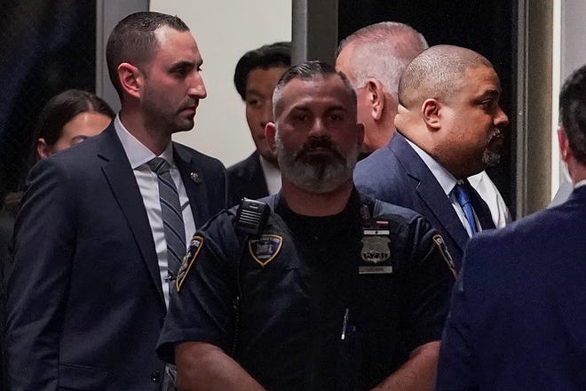 Manhattan District Attorney Alvin Bragg, far right, passes through a hallway outside the courtroom, Tuesday, April 4, 2023, in New York. Trump is set to appear in a New York City courtroom on charges related to falsifying business records in a hush money investigation, the first president ever to be charged with a crime.