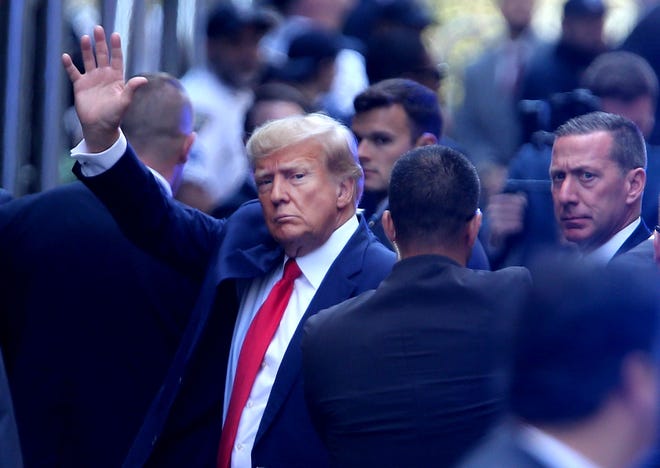 Former president Donald Trump is illuminated by blue strobe lights as he arrives at Manhattan Criminal Court in New York City Tuesday, April 4, 2023.