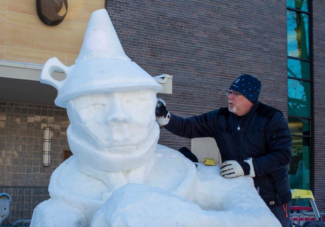 Neal Vogt, of Pewaukee, Wis., fine tunes his snow carving he calls broken, Saturday, February 11, 2023, in Fond du Lac, Wis.