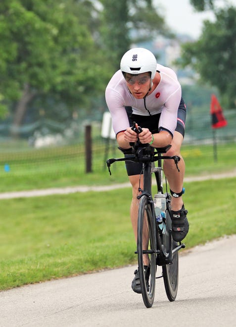 A competitor rides through Water Works Park during the Ironman North American Championship 140.6-mile Des Moines Triathlon as athletes compete in a 2.4-mile swim at Gray’s Lake, 112-mile bike race, and a 26.2-mile run in Des Moines on Sunday, June 12, 2022. This regional competition will offer qualifying slots to the 2022 Ironman World Championship in Kailua-Kona, Hawaii in early October 2022.